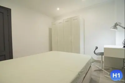 a white bedroom with a bed and a desk at Despuig Delight in Valencia