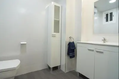 a white bathroom with a toilet and a sink at Despuig Delight in Valencia
