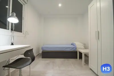 a small room with a bed and a desk and a chair at Despuig Delight in Valencia