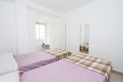 two beds in a room with white walls at Relaxing Reina in Valencia
