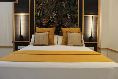 a bedroom with a large bed with yellow sheets and pillows at Promotur Suites - Ayora in Valencia