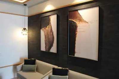 a waiting room with two chairs and paintings on the wall at Promotur Suites - Ayora in Valencia