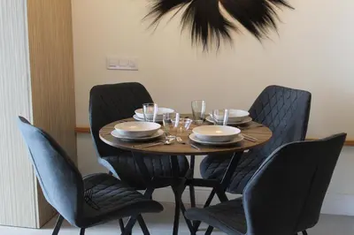a dining room table with chairs and a table with glasses at Promotur Suites - Ayora in Valencia