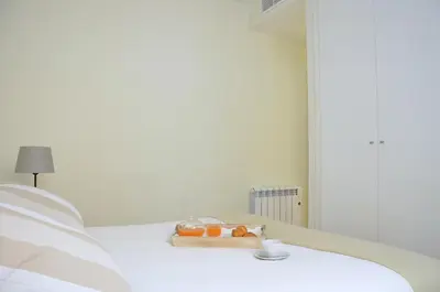 a white bed with a tray of food on it at SingularStays Comedias in Valencia