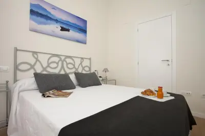 a bedroom with a bed with a plate of food on it at SingularStays Comedias in Valencia