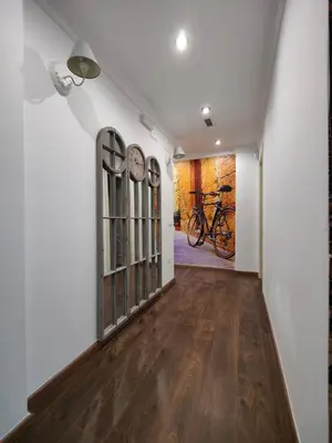 a hallway with white walls and wooden floors and a bike on the wall at Casona Torrent in Torrent