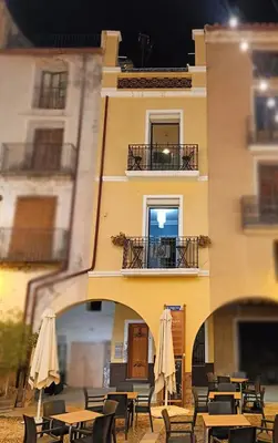 a building with tables and umbrellas in front of it at Plaça de l'Almudí, where else! in Onda
