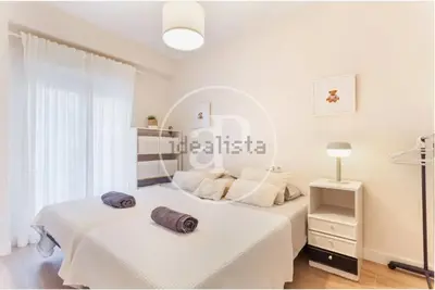 two beds in a white room with a mirror at Estación Central Family Home in Valencia
