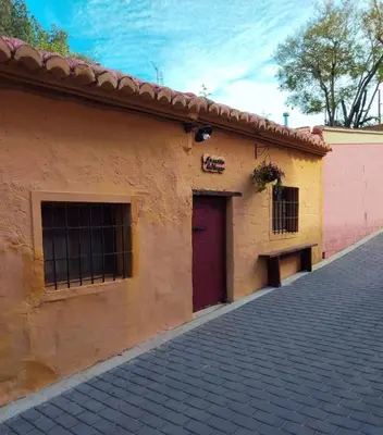 a building with a red door on the side of it at La casita del Horno in Pedralba