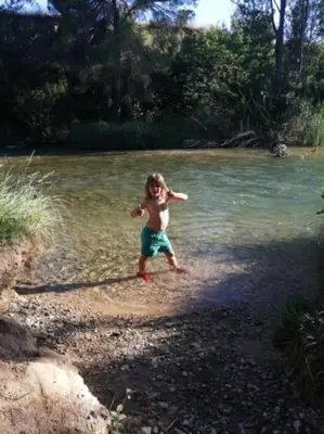 a young child is standing in the water at La casita del Horno in Pedralba
