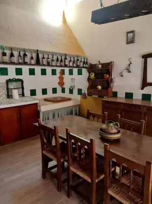 a kitchen with a wooden table and chairs at La casita del Horno in Pedralba