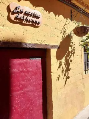 a building with a pink door and a sign on it at La casita del Horno in Pedralba