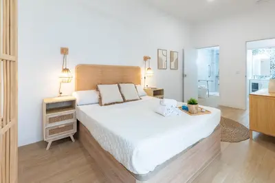 a bedroom with a large bed and a bathroom at Travel Habitat Zaidia con Terraza in Valencia