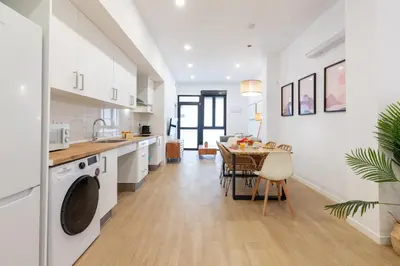 a kitchen and dining room with white cabinets and a table at Travel Habitat Zaidia con Terraza in Valencia