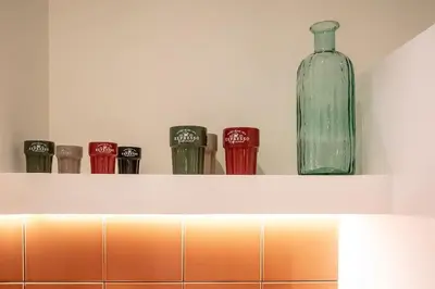 a shelf with a glass bottle and other cups at Suite de lujo estilo mediterráneo in Valencia