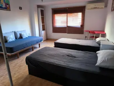 a room with three beds and a couch and a window at Valencia in Valencia