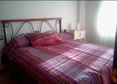 a bed with a purple comforter in a bedroom at Valencia in Valencia