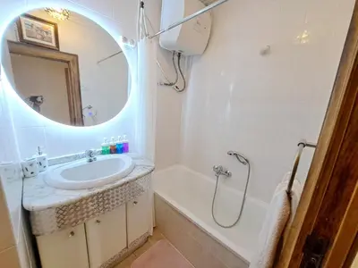 a bathroom with a sink and a tub and a mirror at Apartamento exterior de tres habitaciones in Valencia