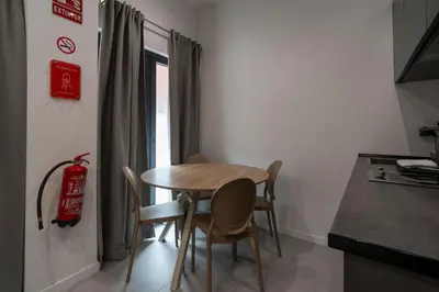a small table and chairs in a room with a window at VLC HOST - Bellvis in Valencia