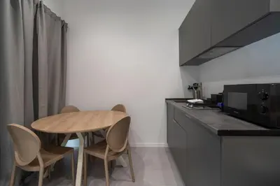 a kitchen with a wooden table and two chairs at VLC HOST - Bellvis in Valencia