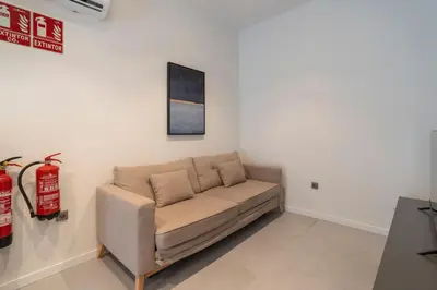 a couch in a living room with a fire extinguisher at VLC HOST - Bellvis in Valencia