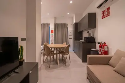 a kitchen and living room with a table and a couch at VLC HOST - Bellvis in Valencia