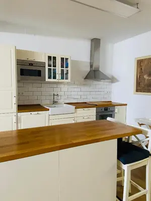 a kitchen with white cabinets and a wooden counter top at VILLA FALI in Benaguacil