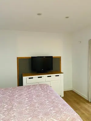 a bedroom with a bed and a flat screen tv at VILLA FALI in Benaguacil