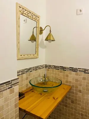 a bathroom with a glass sink and a mirror at VILLA FALI in Benaguacil