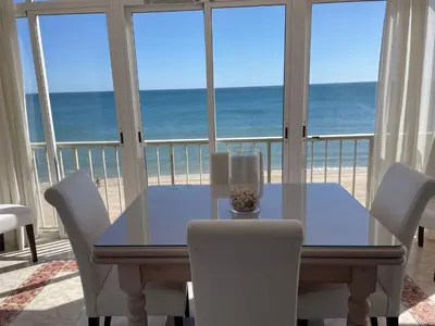 a dining room table with a view of the beach at Apartamento con Vistas Panorámicas in Sueca