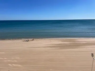 a sandy beach with the ocean in the background at Apartamento con Vistas Panorámicas in Sueca