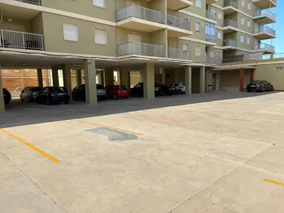 a parking lot in front of a large apartment building at Apartamento con Vistas Panorámicas in Sueca