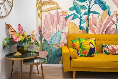 a yellow couch in a living room with a tropical mural at Artistic flat next to Ruzafa Welcome to the Jungle in Valencia