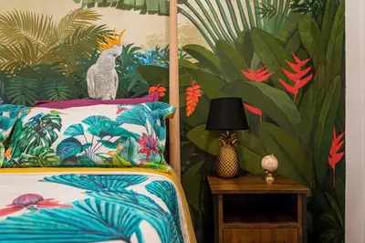 a bedroom with a bed with a tropical wallpaper at Artistic flat next to Ruzafa Welcome to the Jungle in Valencia