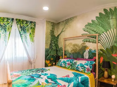 a bedroom with a bed with a tropical wallpaper at Artistic flat next to Ruzafa Welcome to the Jungle in Valencia