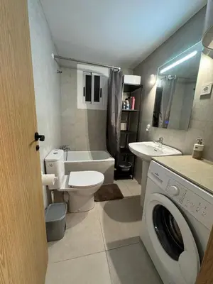 a bathroom with a toilet sink and a washing machine at Apartamento en Cullera in Cullera