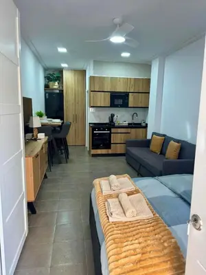 a room with a bed and a kitchen and a couch at UIM Mediterraneo Estudio PB San Jose Wifi in Puerto de Sagunto