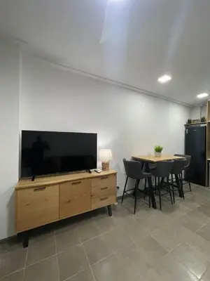 a living room with a flat screen tv and a table at UIM Mediterraneo Estudio PB San Jose Wifi in Puerto de Sagunto