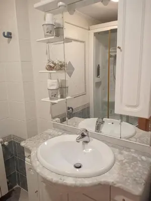 a white bathroom with a sink and a mirror at Relájate en pareja o familia!!! in Tavernes de Valldigna