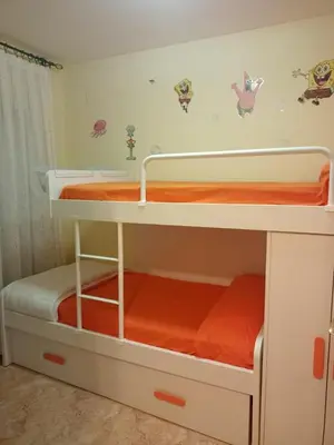 a bedroom with two bunk beds with orange sheets at Relájate en pareja o familia!!! in Tavernes de Valldigna