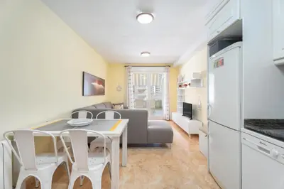 a kitchen and living room with a table and a couch at Relájate en pareja o familia!!! in Tavernes de Valldigna