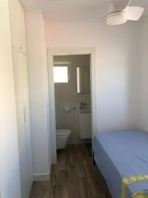 a bedroom with a bed and a bathroom with a toilet at Modern Apartment Frontline Beach in Mareny Blau