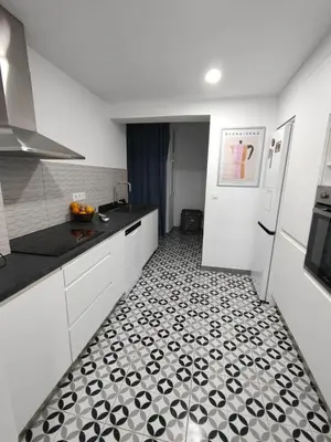 a kitchen with a black and white tile floor at SuecaRoom Prime Experience in Sueca