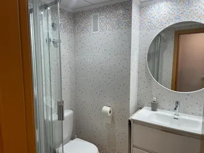 a bathroom with a toilet and a sink and a mirror at Excelente ático con gran terraza y barbacoa en Canet d'en Berenguer in Valencia
