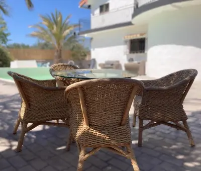 three wicker chairs and a table on a patio at Villa Torre Macastre, Valencia in Macastre