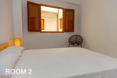 a bedroom with a white bed and a window at Cullera Beachfront Apartment in Cullera