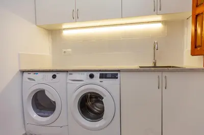 a kitchen with a washing machine and a sink at Cullera Beachfront Apartment in Cullera