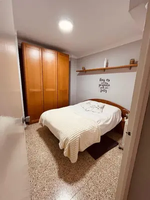 a bedroom with a bed and a wooden cabinet at El Molino Buñol Apartamento in Buñol