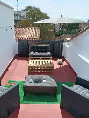 a rooftop patio with a couch and a table at El Molino Buñol Apartamento in Buñol