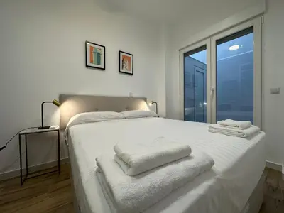 a bedroom with a white bed with towels on it at Valdeolivas Suites in Valencia